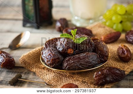 Ramadan Food And Drinks Concept. Ramadan Lantern With Milk, Dates Fruit, Grape And Mint Leaves On Wo