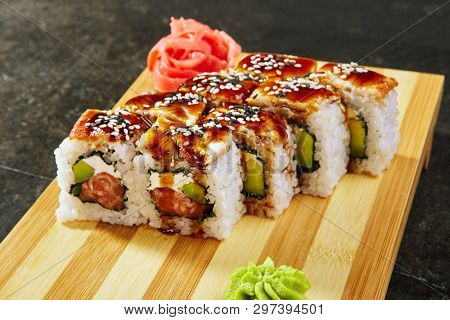 Kanada sushi rolls with salmon, eel, Philadelphia cheese, avocado and cucumber served on wood dish. Asian menu