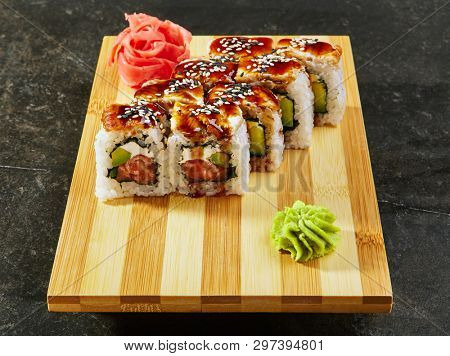 Kanada sushi rolls with salmon, eel, Philadelphia cheese, avocado and cucumber served on wood dish. Asian menu