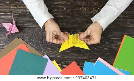 Man Made Origami Butterfly, Top View. Origami Figures, Colorful Paper And Male Hands. How To Make An