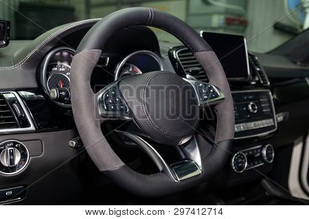 Interior View With Steeering Wheel And Dashboard Of Luxury Very Expensive New White Car Stands In Th