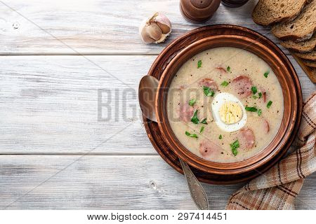 Traditional Polish Soup Zurek In Ceramic Bowl On Wooden Table