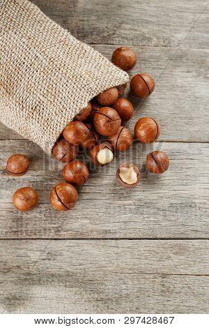 Macadamia Nut On A Wooden Table In A Bag, Closeup, Top View