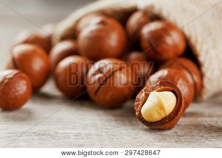 Macadamia Nut On A Wooden Table In A Bag, Closeup, Top View