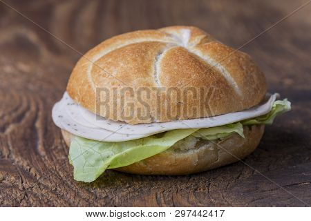 Closeup Of A Bun On Wood With Sausage