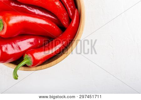 Red Pepper In Wooden Bowl On White Background. Top View, Copy Space, Close-up. Ramiro Pepper.