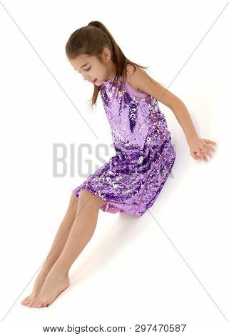 A Cute Little Girl Leaned Against A White Wall. Cyclorama In Studio. Isolated On A White Background.