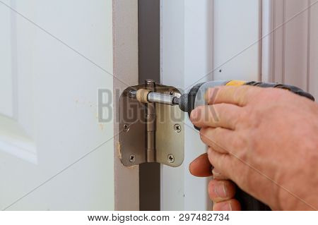 Screwing Metal Chrome Hinges Installation On A Process Of Wood Door