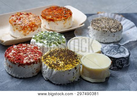 Assortment Of French Fresh White Soft Goat Cheeses With Different Tastes Topping Made With Herbs, Pa