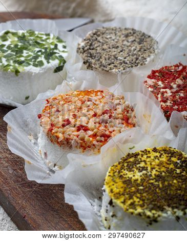 Assortment Of French Fresh White Soft Goat Cheeses With Different Tastes Topping Made With Herbs, Pa