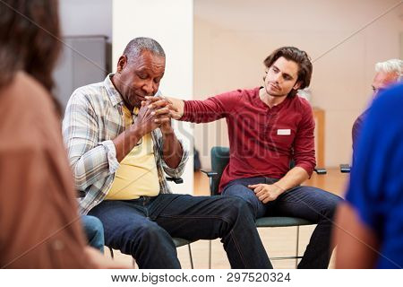 Unhappy Man Attending Self Help Therapy Group Meeting In Community Center