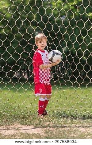 26.06.2018 Russia, Moscow. Caucasian Boy In Football Sportswear Of Red And White Color Stands In A G