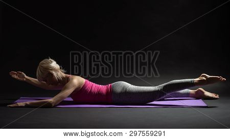 Woman Exercising Pilates. Contralateral Limb Raises Exercise. Studio Shot.