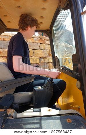 Teenager Sitting In A Mini Digger Cab