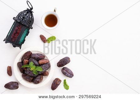 Ramadan Food And Drinks Concept. Ramadan Lantern With Tea, Dates Fruit, Grape And Mint Leaves On A W