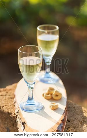 Two Glasses Of Fresh White Wine On A Wooden Board A Traditional Italian Snack - Taralli On A Bright 
