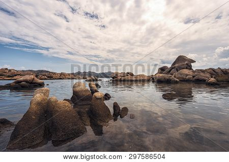 Rounded Rocks By The Sea Water In The Beach Of Testa Di Polpo In La Maddalena, Sardinia, Italy