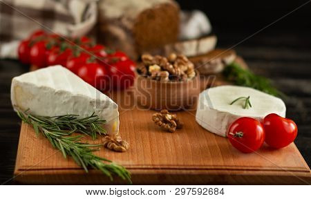 Rye Bread With Brie And Camembert Cheeses, Nuts, Honey, Cherry Tomatoes And Rosemary On A Wooden Boa