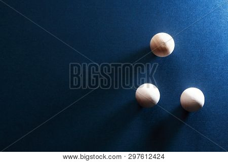 Abstract Composition With Three Small Wooden Balls On Dark Blue Background
