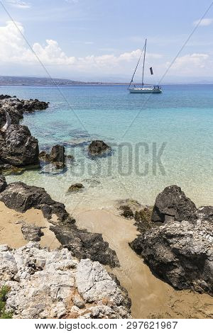 A Sailing Boat Anchored At A Bay With Crystal Clear Water On The Island Of Crete, Greece.