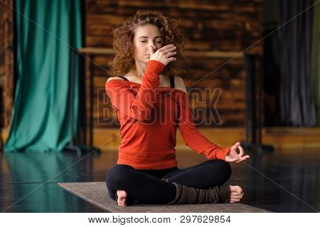 Young Curly Woman Doing Yoga Exercises, Using Nadi Shodhana Pranayama