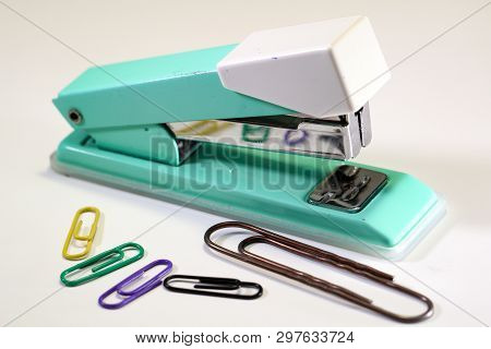 An Old Green Tacker With Color Paperclips