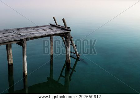 Pier With Ladder With Rose Sunset Colour Reflections In The Lake, El Remate, Peten, Guatemala