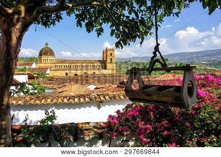 View Of Colorful Garden, Tree And Church In Barichara, Colombia