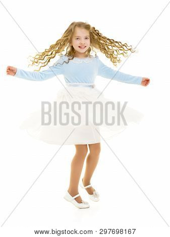 Beautiful Little Girl In A Dress Is Spinning. Concept Of Happy Childhood, Dancing, Holidays. Isolate