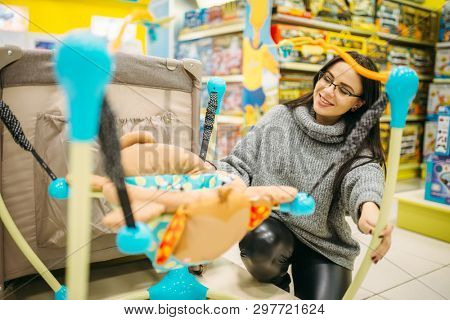Pregnant woman choosing hanging bed in store