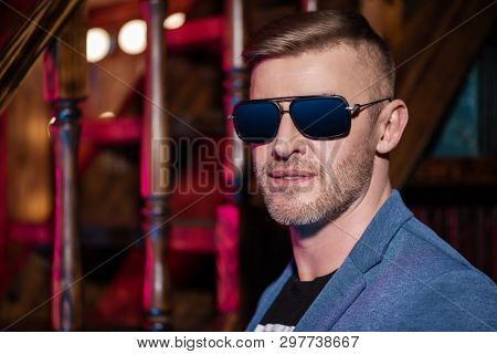 A close up portrait of a brutal handsome man in sunglasses. Men's beauty, fashion. Optics for men.