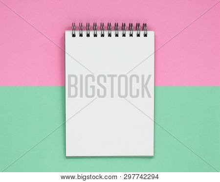 Open Spiral Notepad On A Pink And Green Background. Flat Lay With Copy Space.