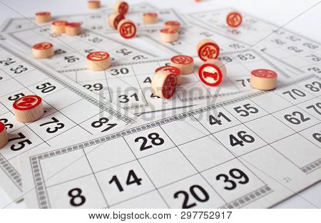 Bingo Or Lotto Game. Wooden Kegs Of Lotto On Cards. Cards And Chips For Playing Bingo On A White Tab