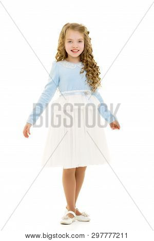 Beautiful Little Girl In A Dress Is Spinning. Concept Of Happy Childhood, Dancing, Holidays. Isolate