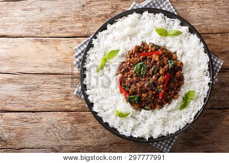 Thai Basil Chicken With Spicy Chili Pepper And Soy Sauce With Rice Garnish Close-up On A Plate. Hori