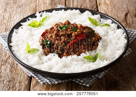 Traditional Basil Chicken With Chili Pepper And Soy Sauce With Rice Garnish Close-up On A Plate. Hor