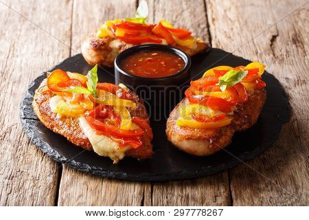 Delicious Baked Chicken Breast With Parmesan Cheese And Bell Peppers, Served With Sauce Close-up On