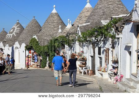 Alberobello, Italy - May 29, 2017: Tourists Visit Alberobello, Italy. Alberobello And Its Trulli Hou