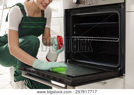 Professional Janitor Cleaning Oven With Sponge In Kitchen, Closeup