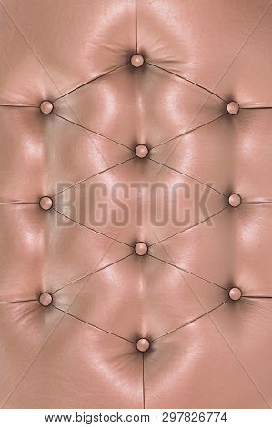Pink Soft Leatherette Background With Symmetrical Buttons. Soft And Expensive Furniture Elements. Lu