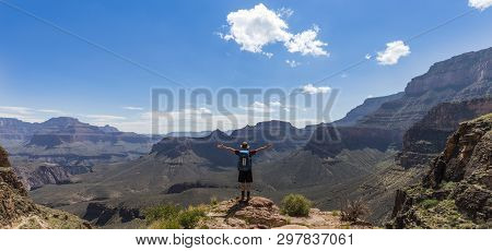 Someone Standing On A Cliff Edge In The Grand Canyon In Arizona, Usa.