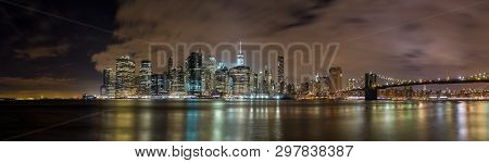 The Skyline Of New York City At Night Time With The East River In Front, Reflections Of The Building