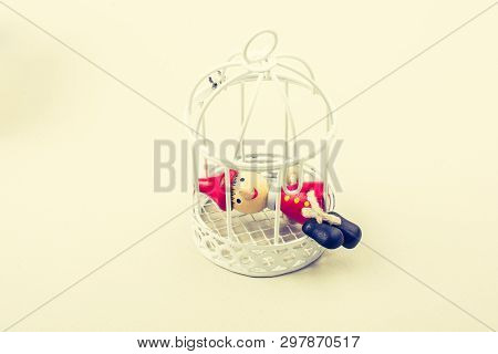 Metal Cage And Little Puppet Pinocchio Made Of Wood
