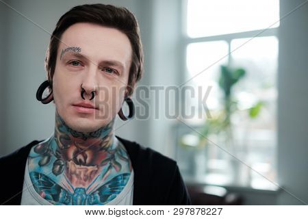 Portrait of alternative model with earplugs and tattoo