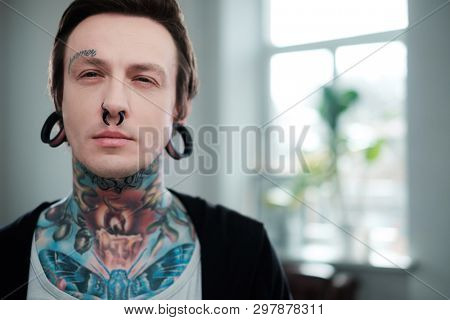 Portrait of alternative model with earplugs and tattoo