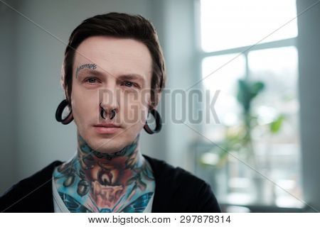 Portrait of alternative model with earplugs and tattoo