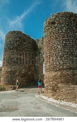 Evoramonte, Portugal - July 06, 2018. Woman And Girl Passing Through The Main Doorway Of Evoramonte.