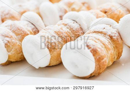 Many small delicious cream rolls background