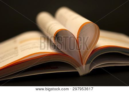 Love To Read A Book Concept. Open Book With Heart Shape Page On Black Table. Education Background, B