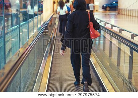 Women At Horizontal Escalator Covered. Moving Walkway, Moving Sidewalk, Moving Pavement, Autopedesca